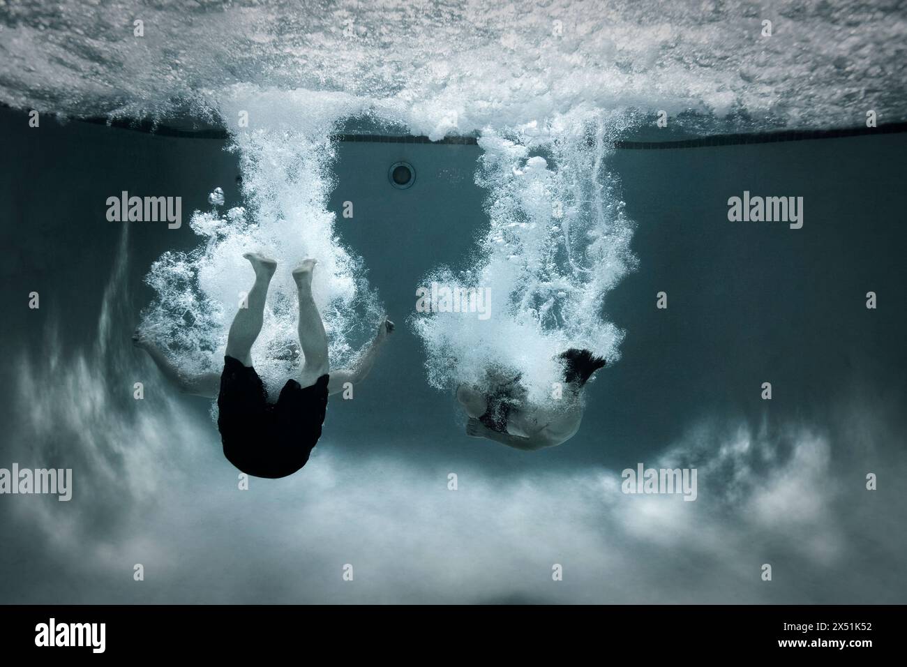 Zwei Männer machen einen Kanonball in einen Pool Stockfoto