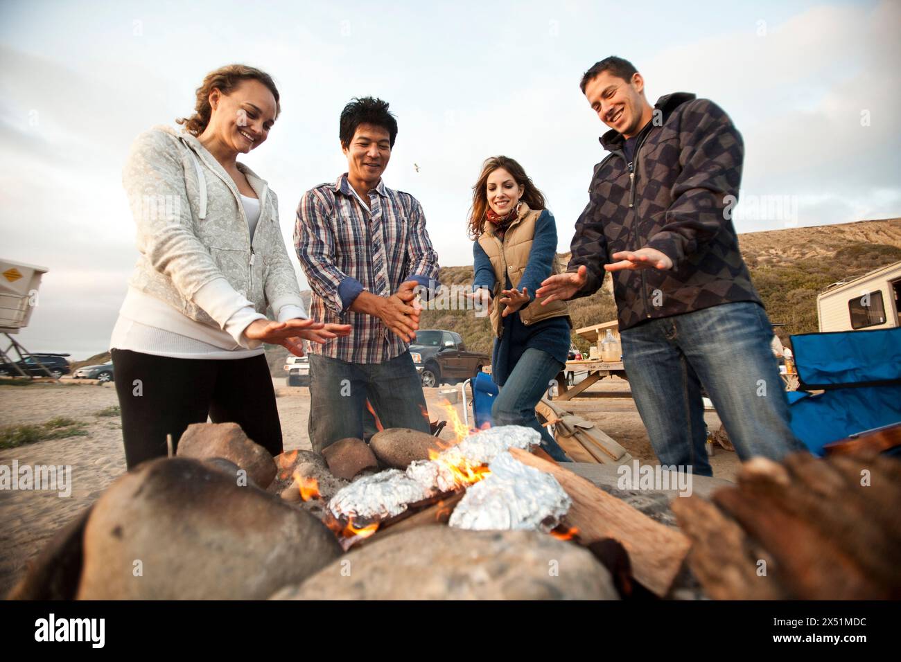 Essen Lifestyle am Strand. Um das Feuer herum Essen zu machen Stockfoto