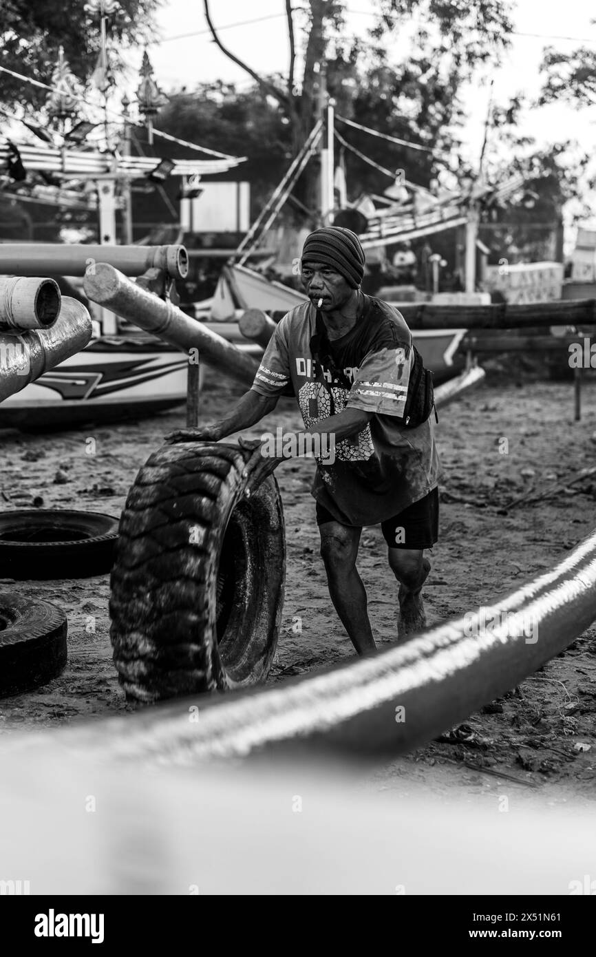 Fischer Rollen ein Fischerboot vom Wasser zum Ufer. Stockfoto