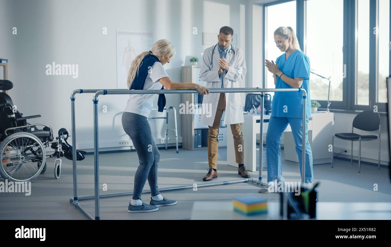 Krankenhaus-Physiotherapie: Starke ältere weibliche behinderte Patientin mit Verletzung, die erste Schritte macht, geht, hält für parallele Stäbe. Physiotherapeut, Rehabilitationsarzt Applaudieren, Alte Frau Ermutigen Stockfoto