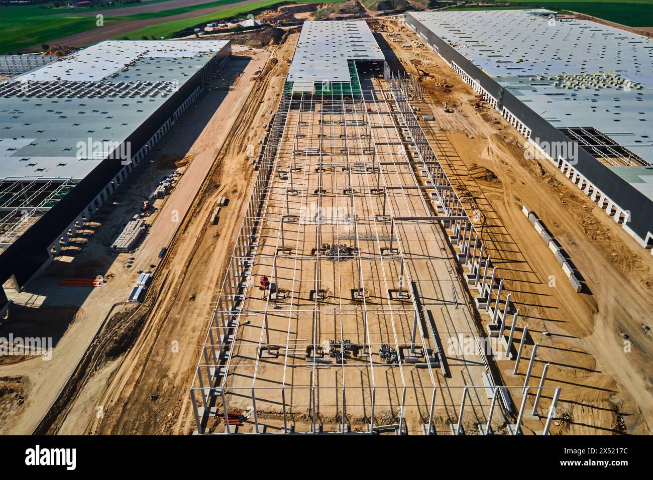 Luftaufnahme der Baustelle mit im Bau befindlichem Lagergebäude zur Lagerung. Montage von Industriebauten mit Stahlrahmenkonstruktion und Stockfoto