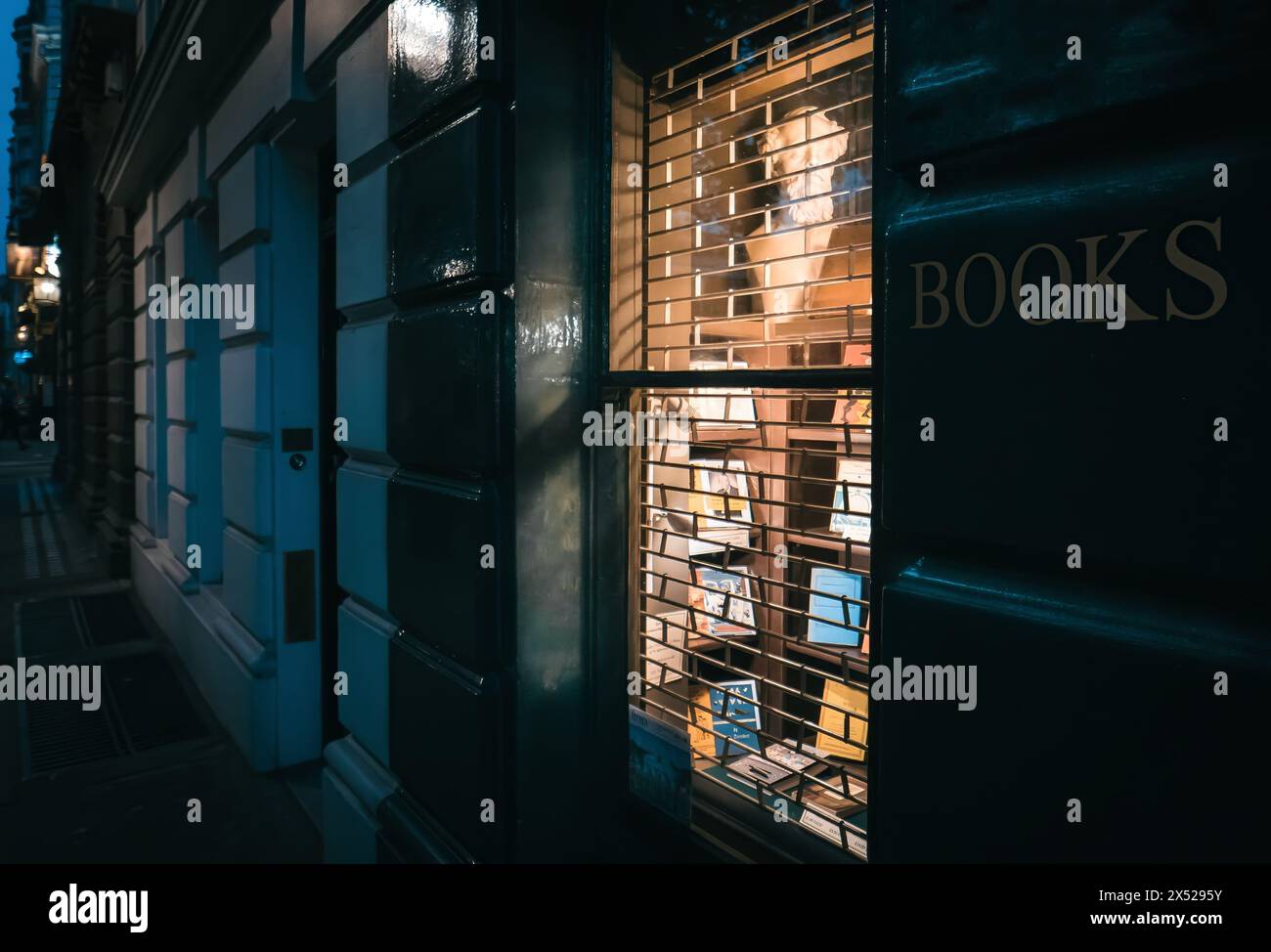 Geschlossener Londoner Buchladen bei Nacht mit warmer Ladenbeleuchtung, London, Großbritannien Stockfoto