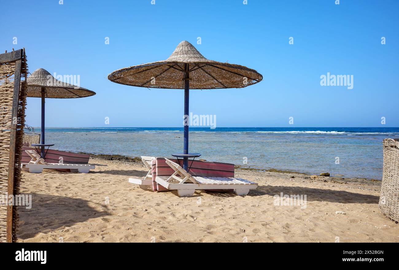 Schöner Sandstrand mit Liegestühlen und Sonnenschirmen, Marsa Alam Region, Ägypten. Stockfoto