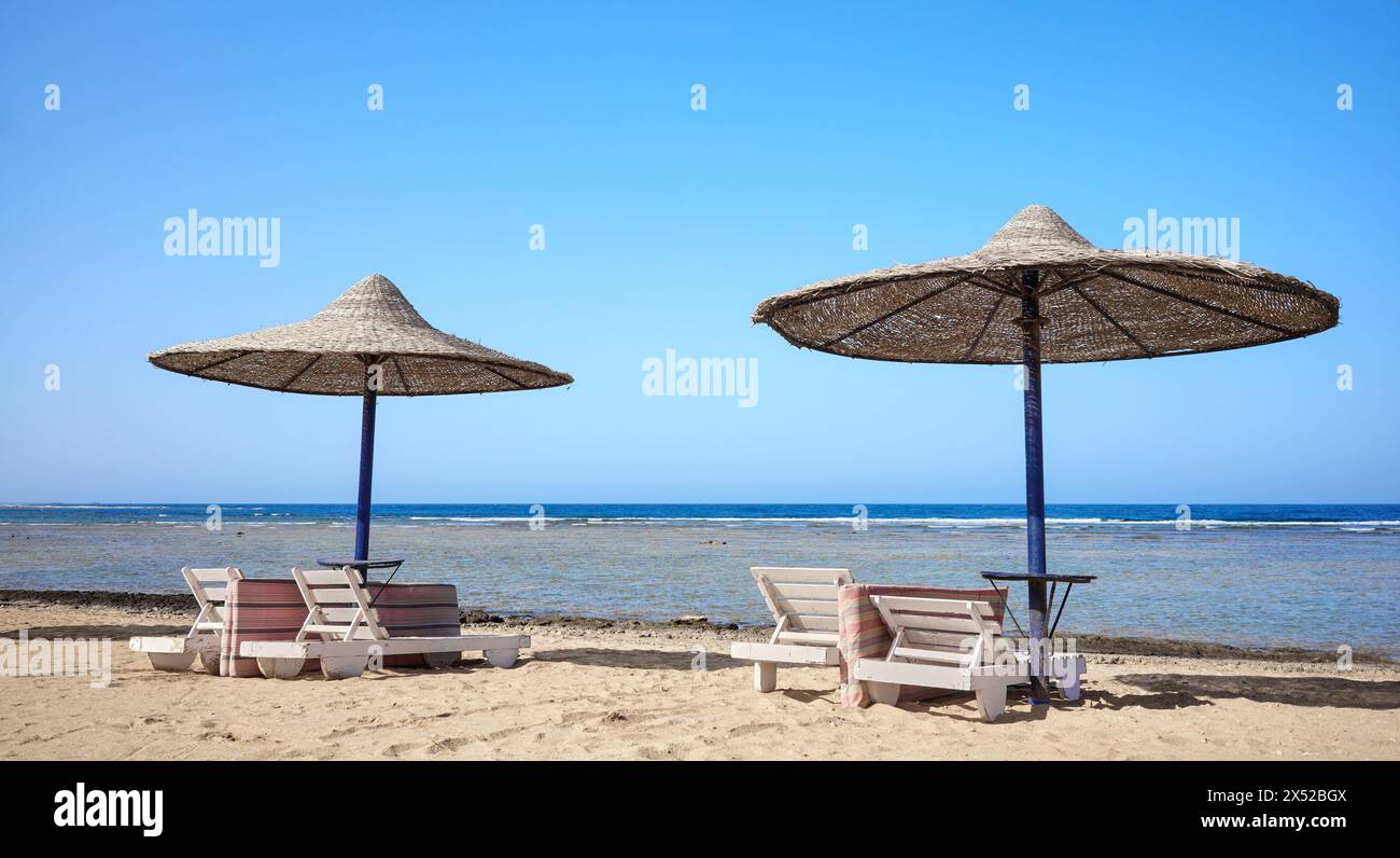 Schöner Sandstrand mit Liegestühlen und Sonnenschirmen, Marsa Alam Region, Ägypten. Stockfoto