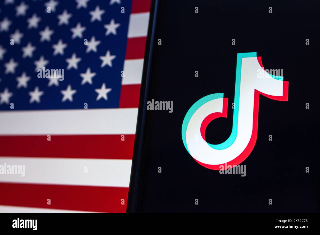 Vancouver, KANADA - April 30 2024 : TikTok-Logo auf einem iPhone-Bildschirm auf amerikanischem Flaggenhintergrund Stockfoto