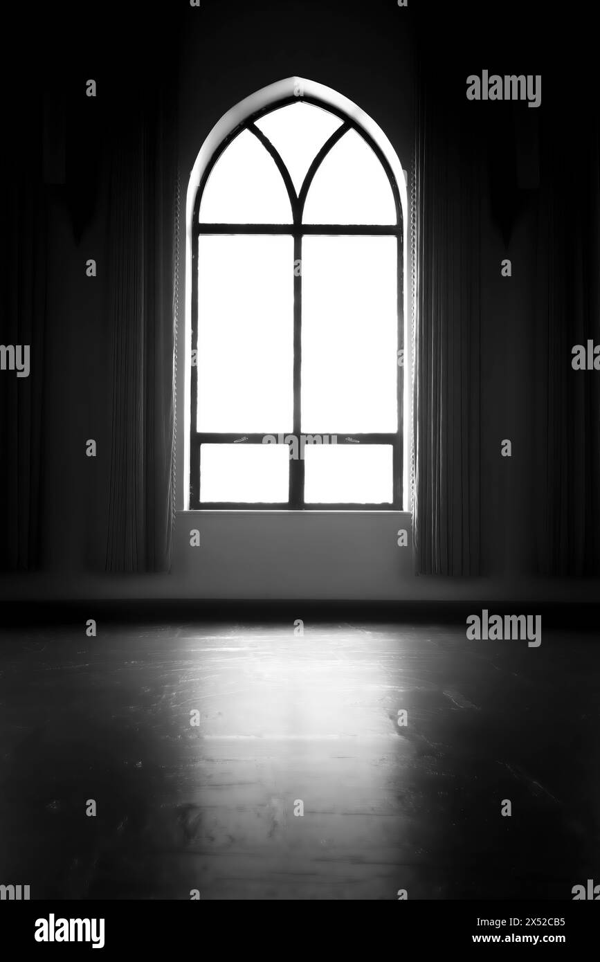 Tageslicht scheint durch das bogenförmige Fenster und füllt den leeren Raum sanft aus. Stockfoto