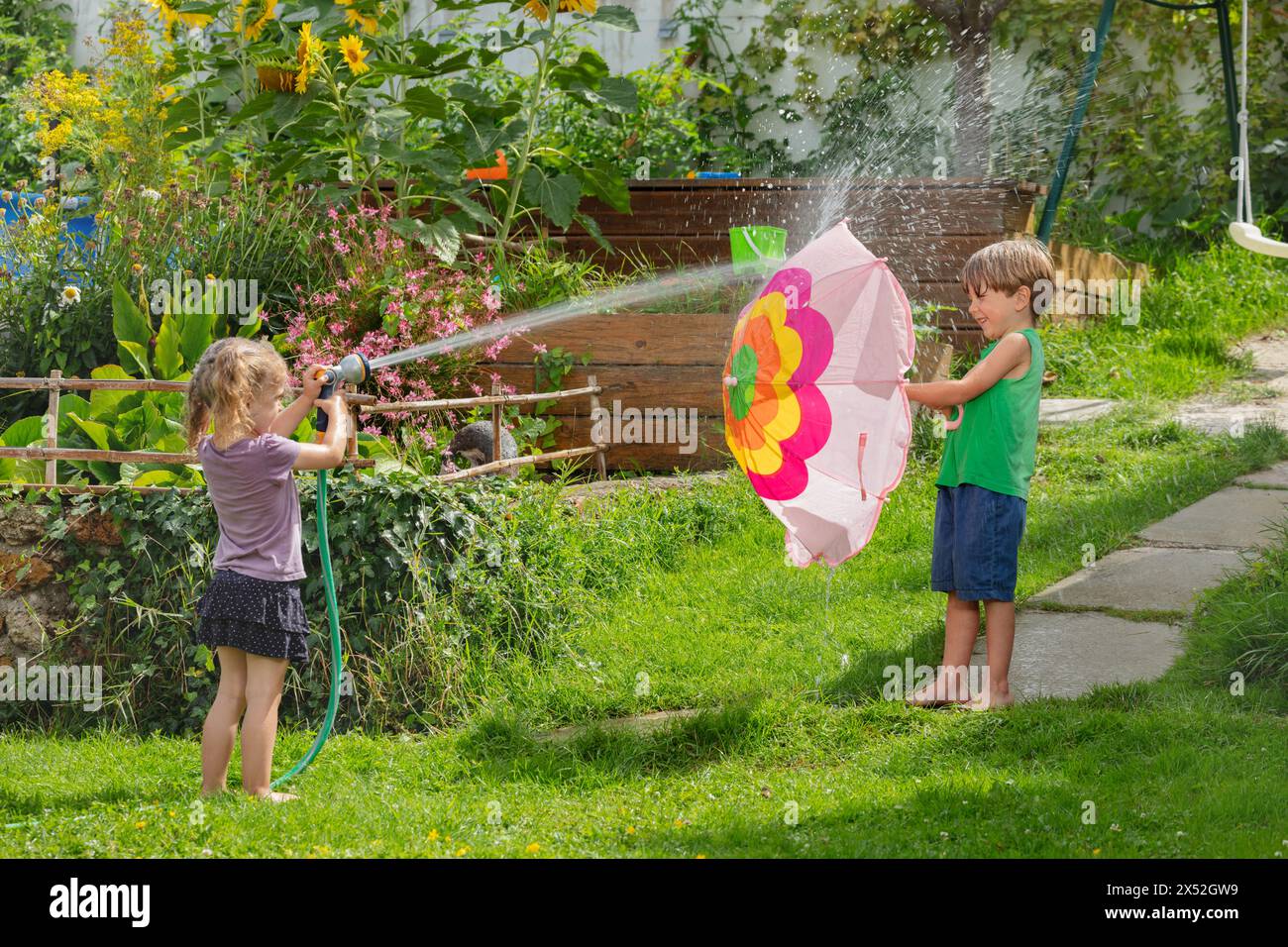 Kinder Jungen und Mädchen genießen im Sommer einen Wasserkampf im Freien Stockfoto