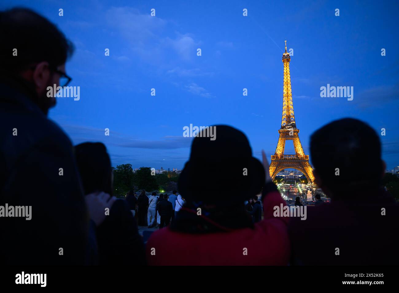 Paris, Frankreich. Mai 2024. Touristen stehen am Abend vor dem Eiffelturm. Die Olympischen Spiele und Paralympics finden im Sommer in Frankreich statt. Robert Michael/dpa/Alamy Live News Stockfoto