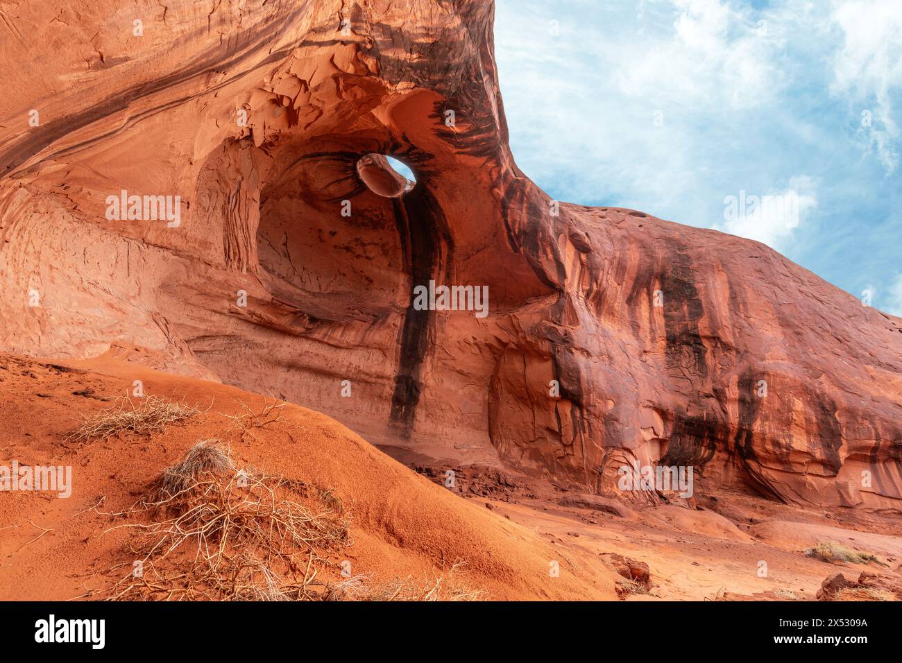 Der Big Hogan Arch im Monument Valley Arizona liegt in einem abgelegenen Teil des Parks und ist aufgrund seines erodierten Sandsteins an der Decke des Bogens, Maki, einzigartig Stockfoto