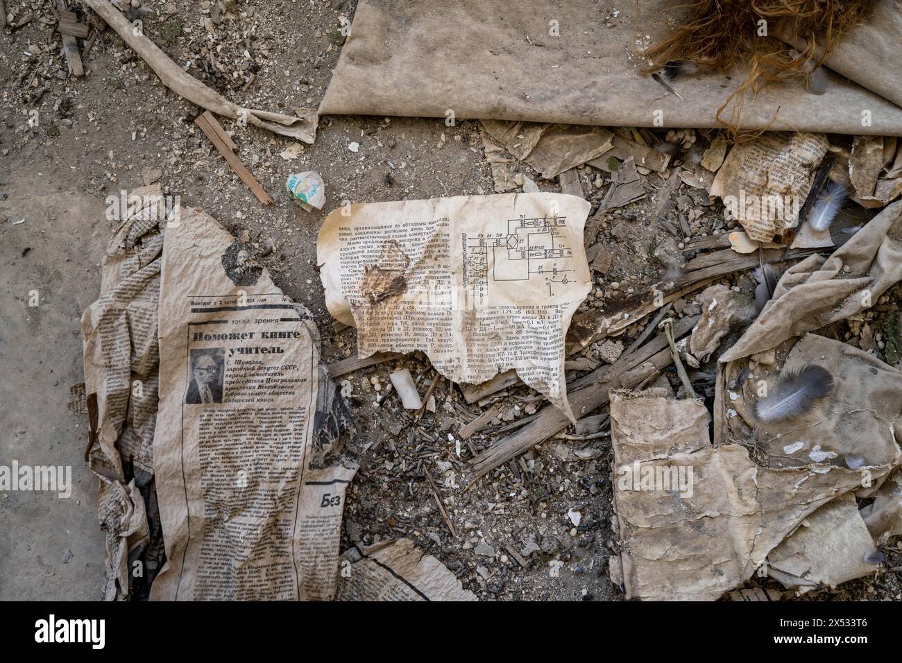 Überreste einer alten kirgisischen Zeitung aus dem Jahr 1924 und eine Bedienungsanleitung mit Schaltplan in kyrillischer Schrift in einem verlassenen Gebäude, Geisterstadt Stockfoto