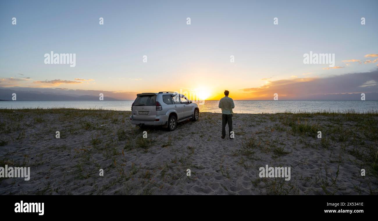 Touristen mit Geländewagen Toyota Land Cruiser am Issyk Kul See bei Sonnenuntergang, Issyk Kul, Kirgisistan Stockfoto