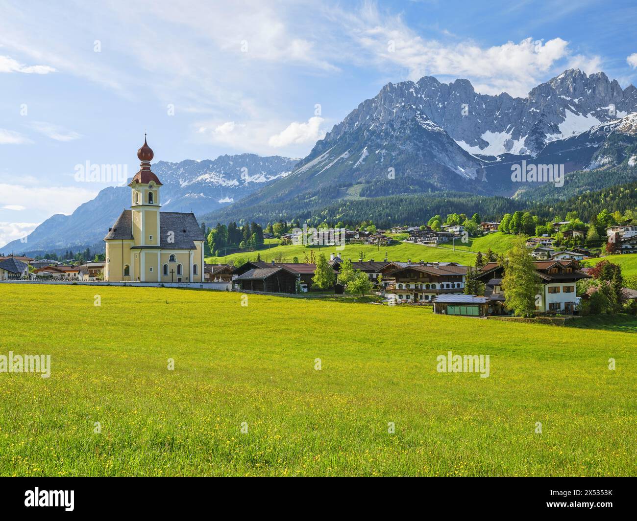 Pfarrkirche Heilig Kreuz in Going am Wilden Kaiser, Kaisergebirge, blauer Himmel und Blumenwiese, Going am Wilden Kaiser, Tirol, Österreich Stockfoto