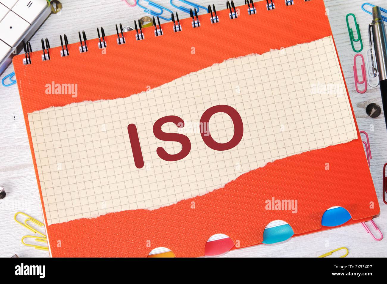 Das Konzept der ISO-Qualitätskontrollzertifizierung. Abkürzung ISO auf einem Blatt in einem Käfig auf dem Hintergrund eines Notizbuchs Stockfoto