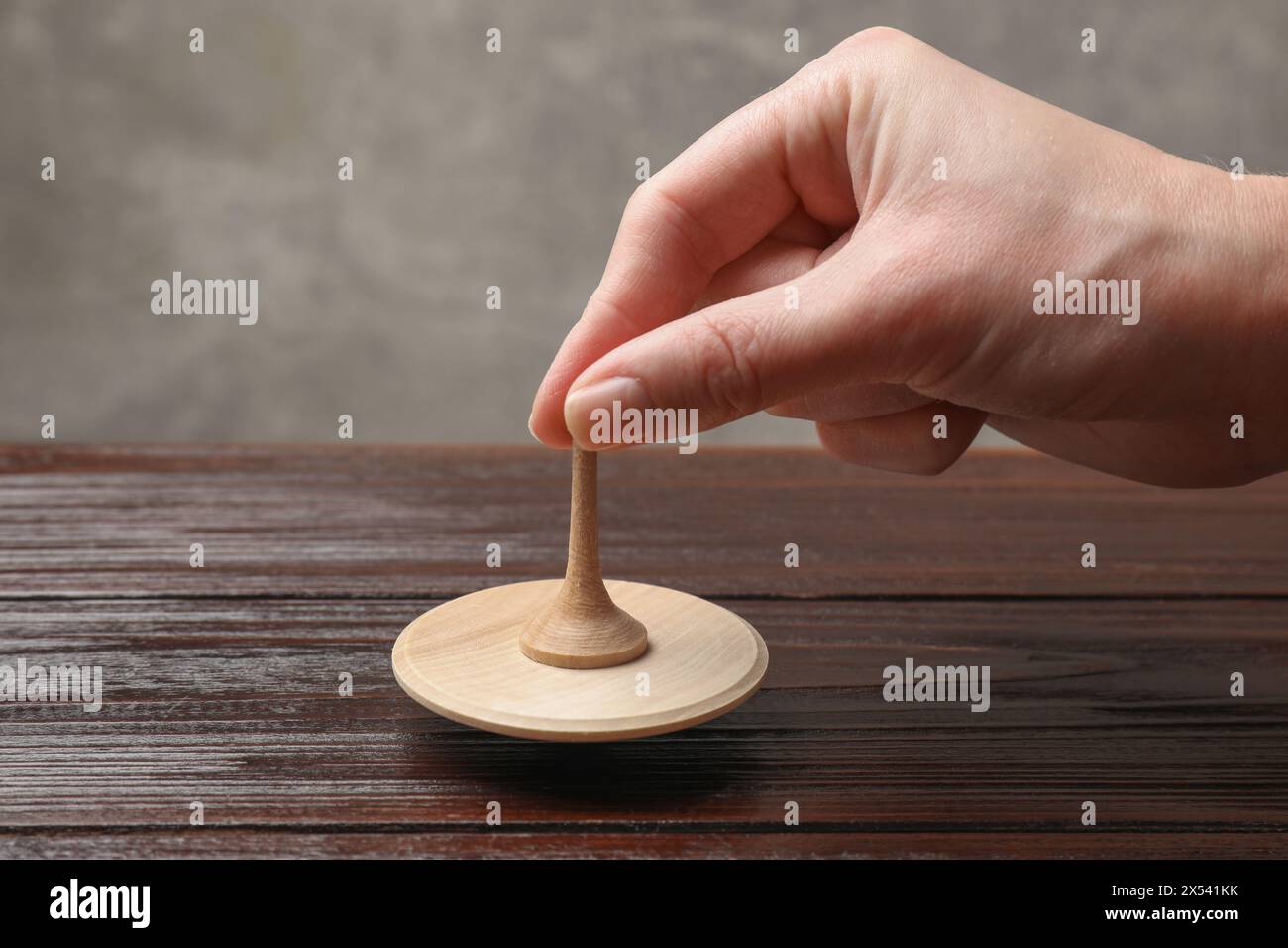 Frau, die mit Spinnplatte am Holztisch spielt, Nahaufnahme Stockfoto