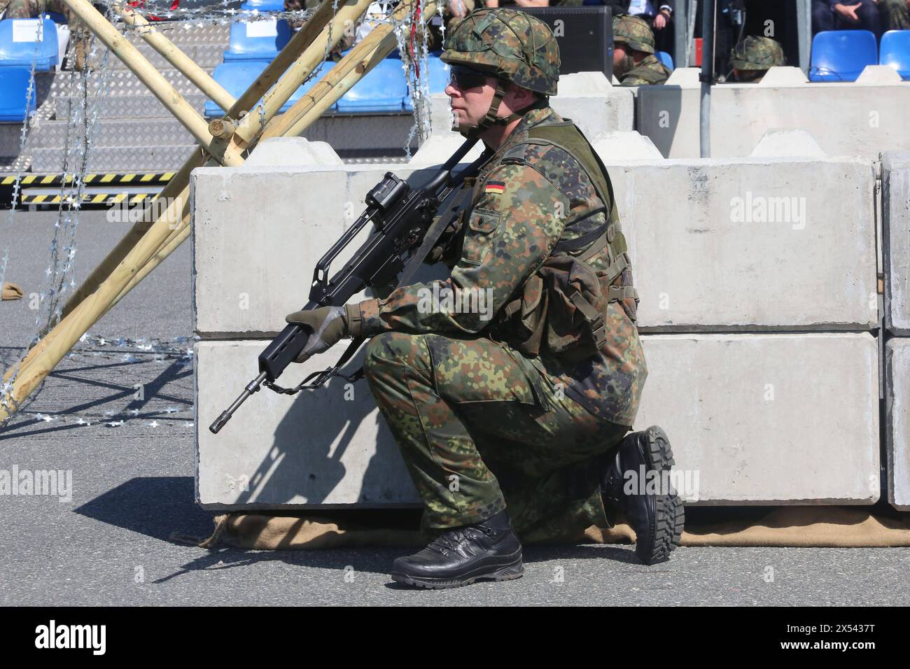 Blick am Freitag 03.05.2024 in der Hanse- und Universitätsstadt Rostock auf den örtlichen Seehafen während der Militärübung National Guardian 24 mit einem Soldaten der einen Kontrollpunkt absichert im Mittelpunkt. Die Großübung ist ein Teil der deutschen Übungsserie Quadriga 2024. Im Rahmen dieser beteiligte sich die Bundeswehr mit rund 12,000 Soldatinnen und Soldaten an dem NATO-Großmanöver standhafter Verteidiger. Im örtlichen Hafen demonstrieren dabei u.a. die Heimatschutzkräfte der Bundeswehr ihre Fähigkeiten. Dabei geht es es insbesondre darum, militärisches Gerät auf Schiffe zu verladen und besti Stockfoto