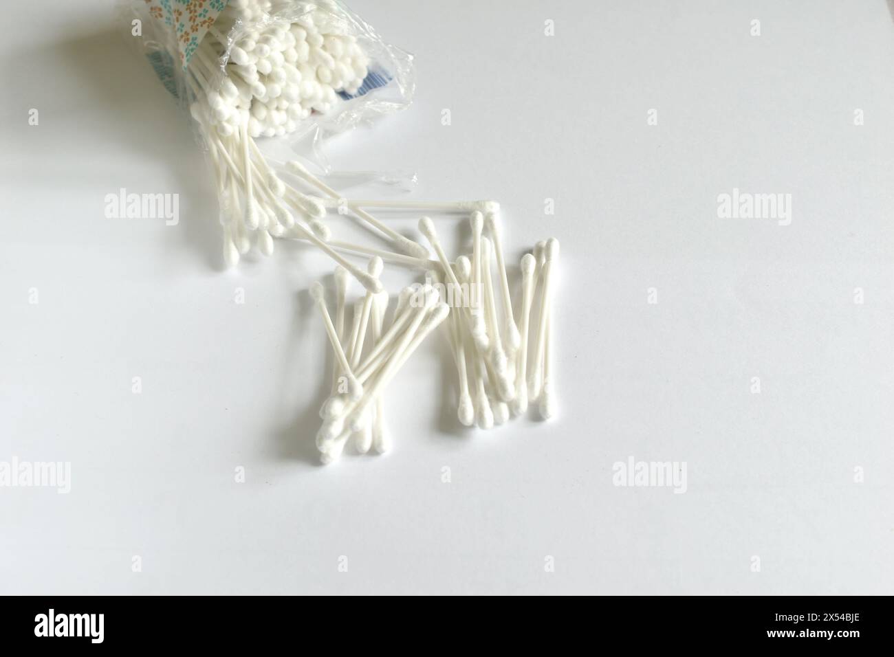 Weiße Wattestäbchen zum Reinigen der Ohren liegen auf weißem Hintergrund. Stockfoto