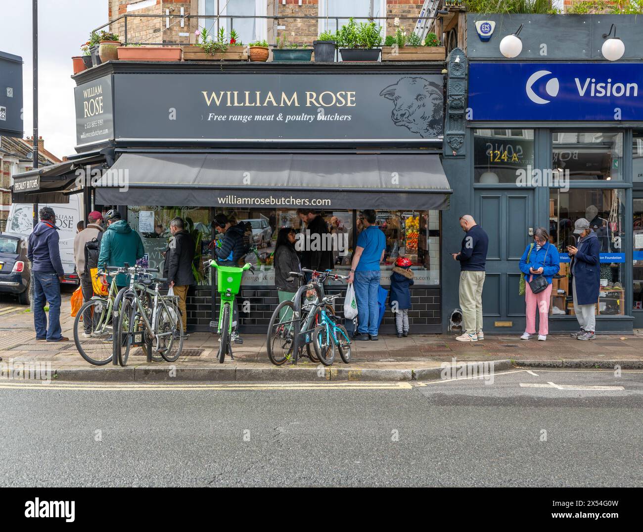 Leute, die vor William Rose Metzgern stehen, East Dulwich, London, England, Großbritannien Stockfoto
