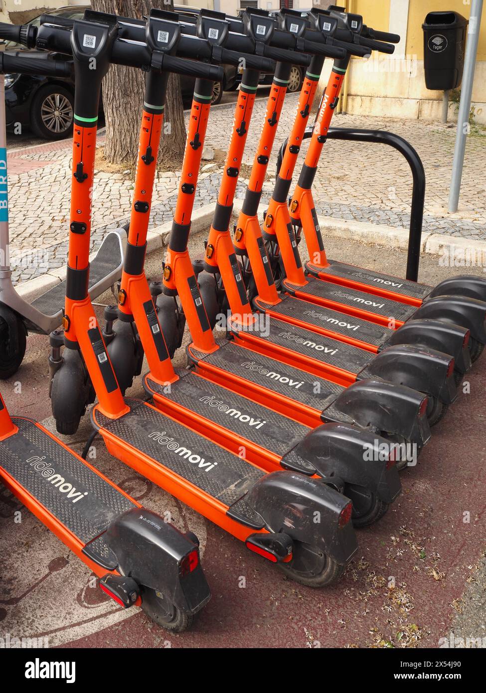 Reihe von orangen Ride Movi Elektrorollern in Faro, der Algarve, Portugal Stockfoto