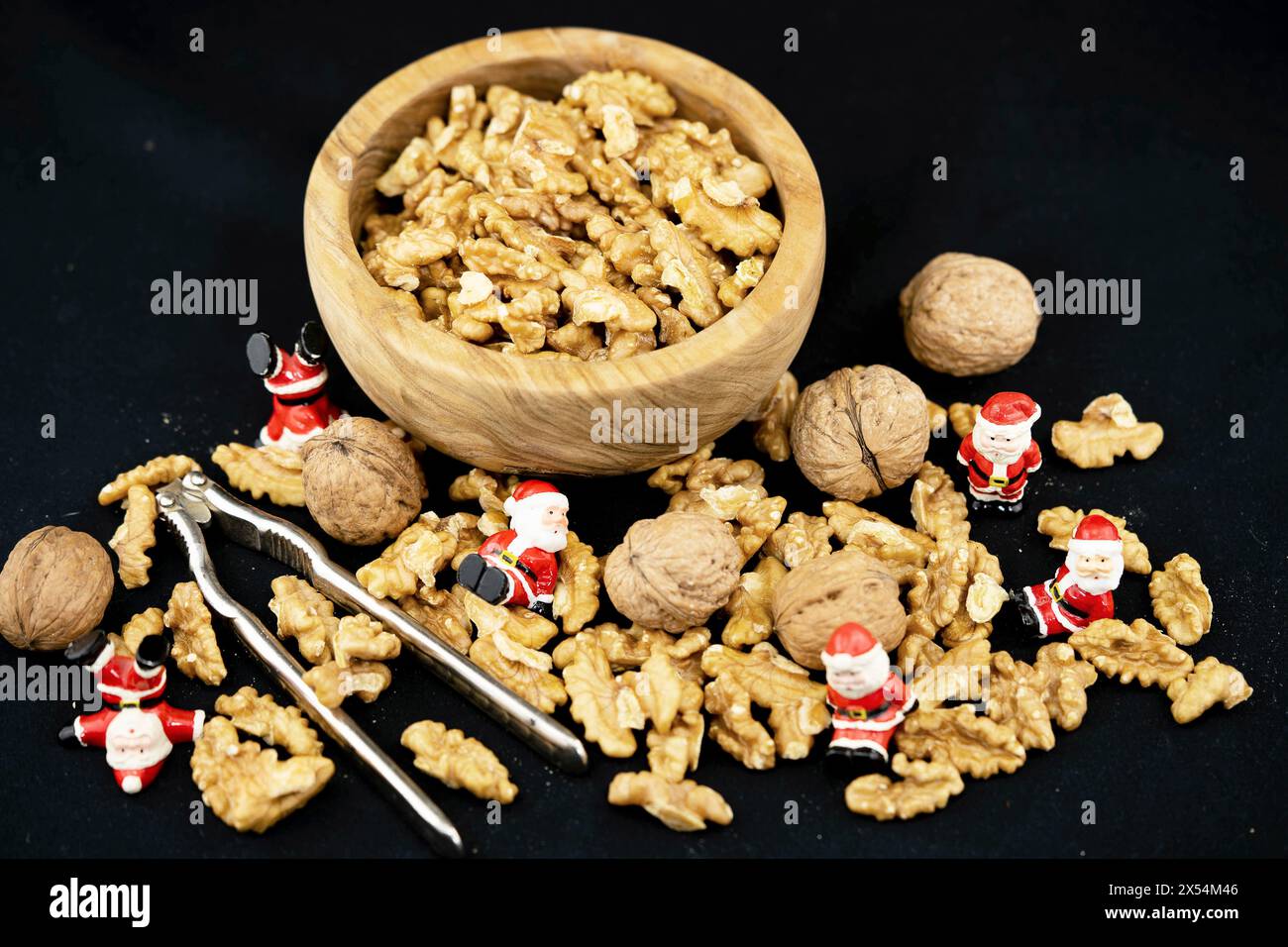 Walnuss (Juglans regia), Walnüsse mit Nussknacker, Holzschale und Weihnachtsmünzen Stockfoto