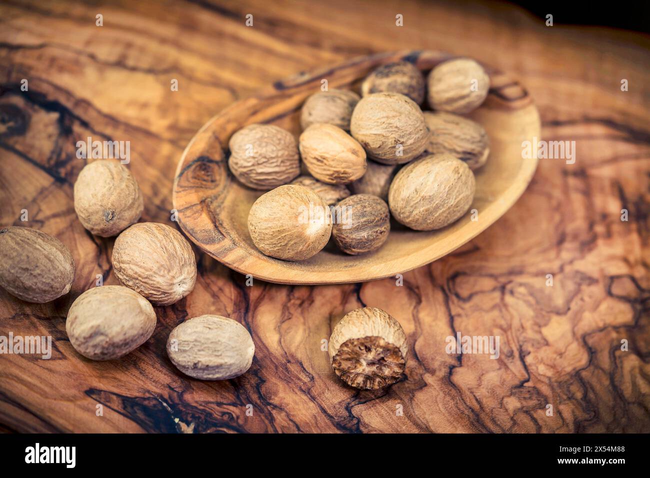 Muskatnuss, Muskatblüte (Myristica duftet), Muskatnuss in einer Holzschale auf einem Holztisch Stockfoto