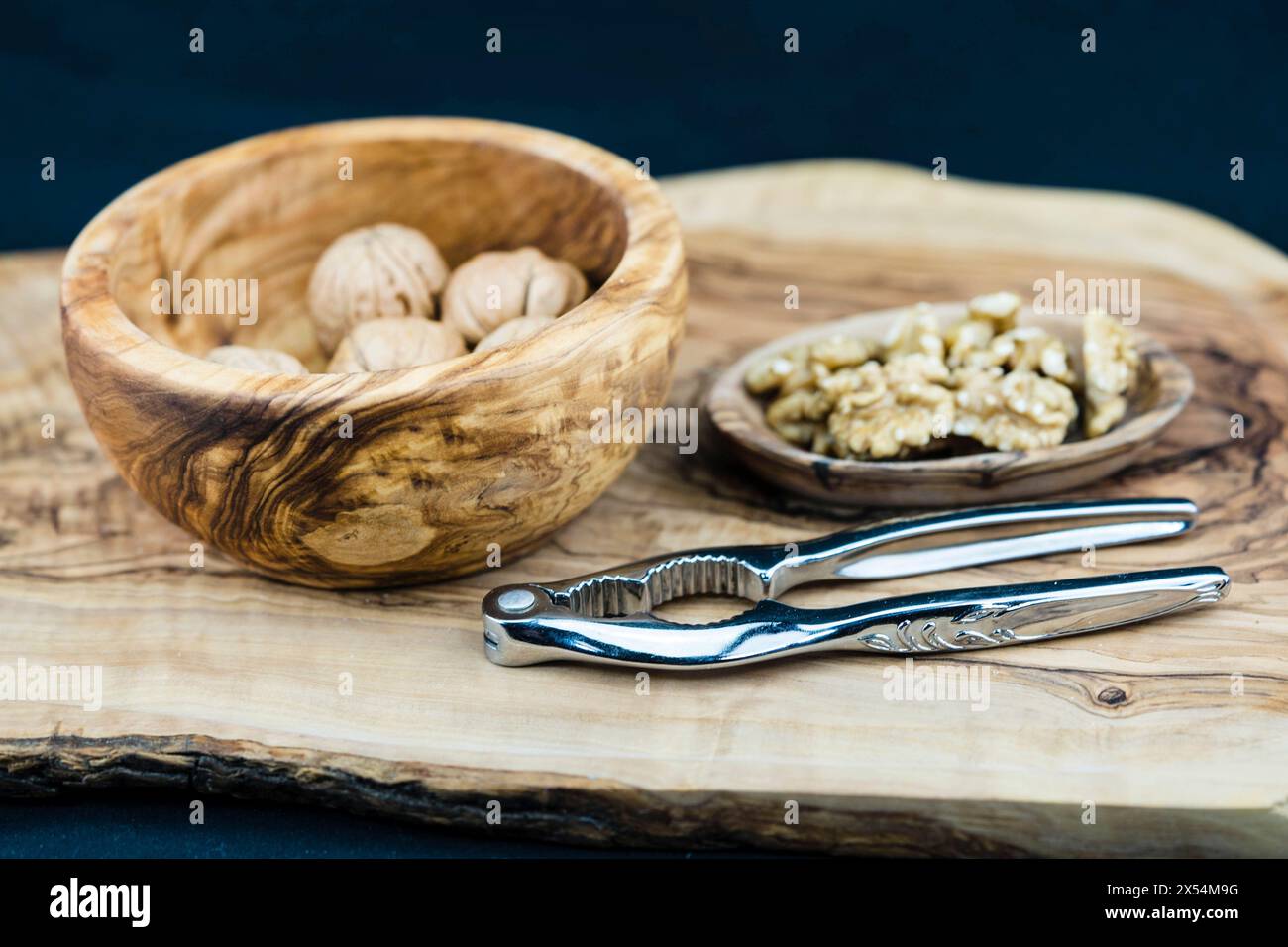 Walnuss (Juglans regia), Walnüsse, ganz und gerissen, mit Nussknacker Stockfoto