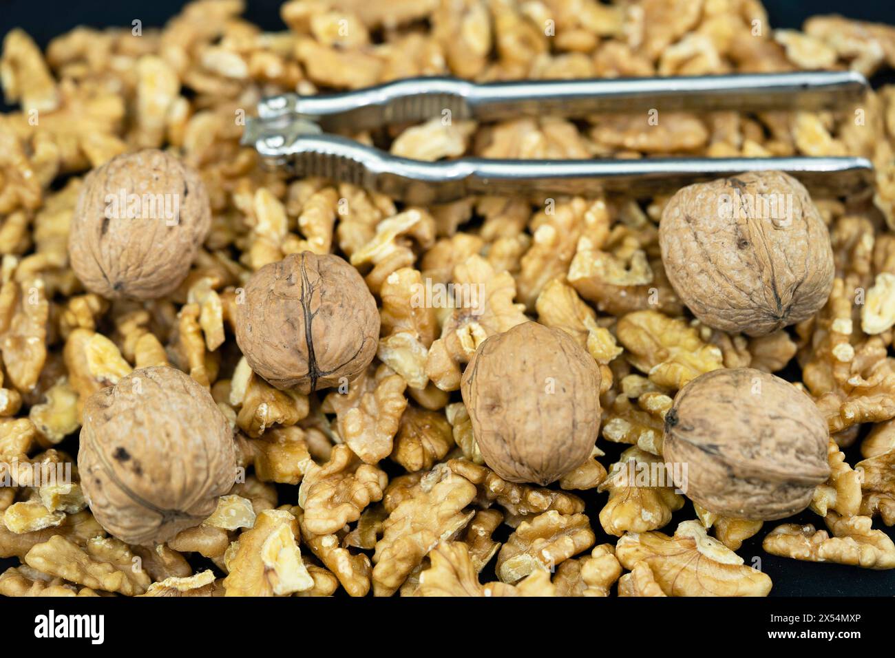 Walnuss (Juglans regia), Walnüsse, ganz und gerissen, mit Nussknacker Stockfoto