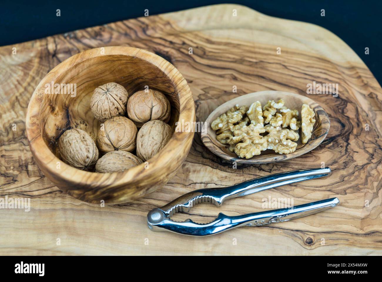 Walnuss (Juglans regia), Walnüsse, ganz und gerissen, mit Nussknacker Stockfoto