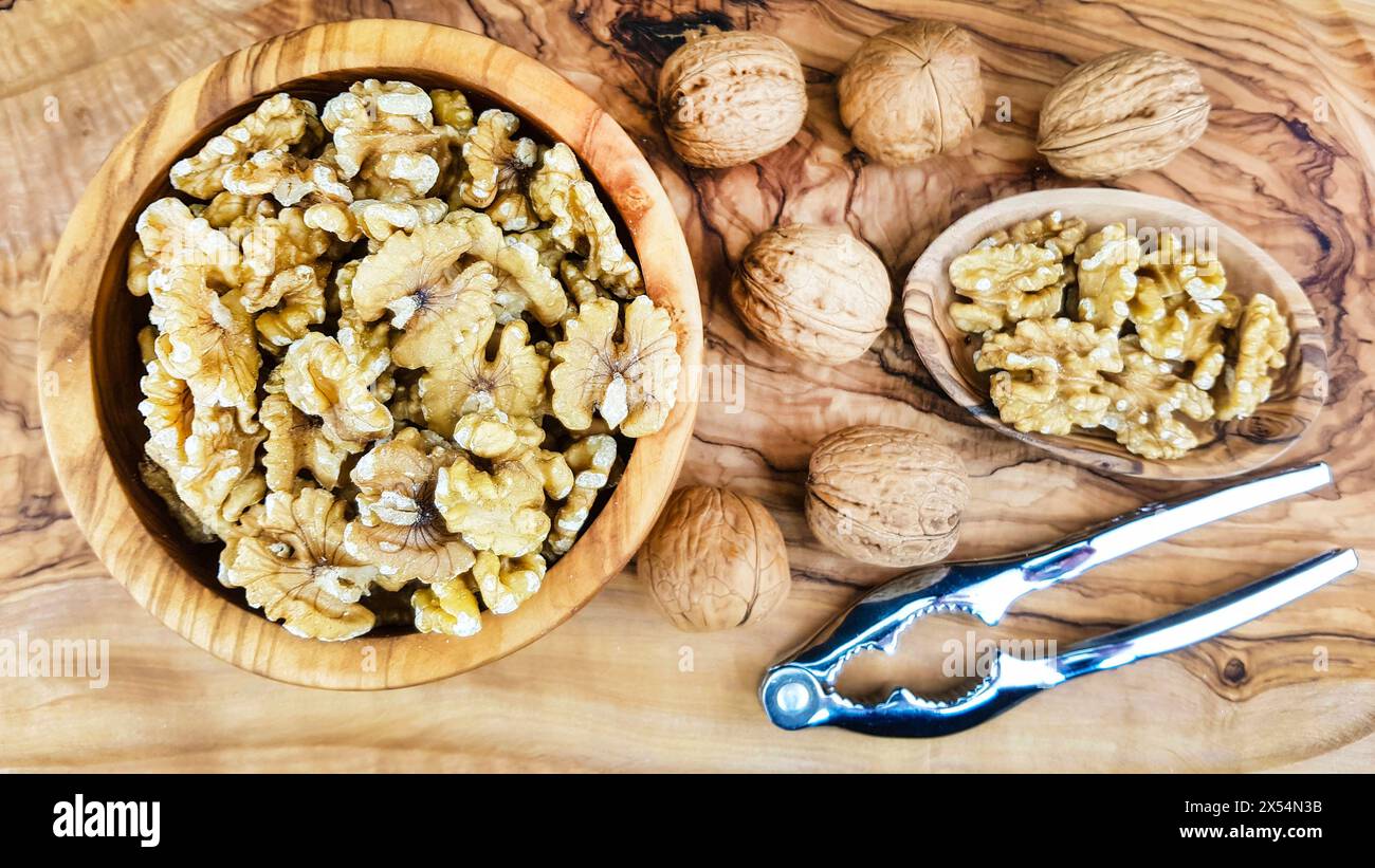 Walnuss (Juglans regia), Walnüsse, ganz und gerissen, mit Nussknacker Stockfoto
