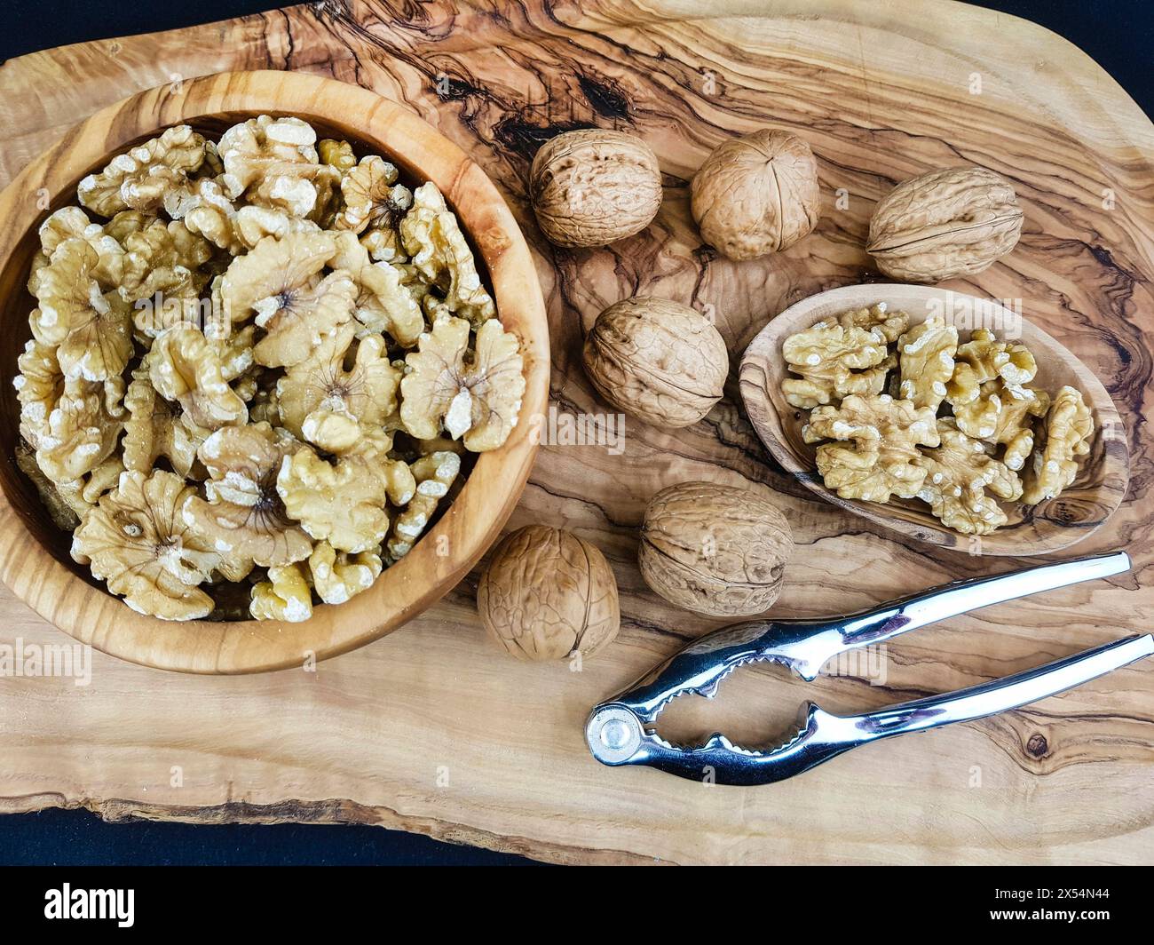 Walnuss (Juglans regia), Walnüsse, ganz und gerissen, mit Nussknacker Stockfoto