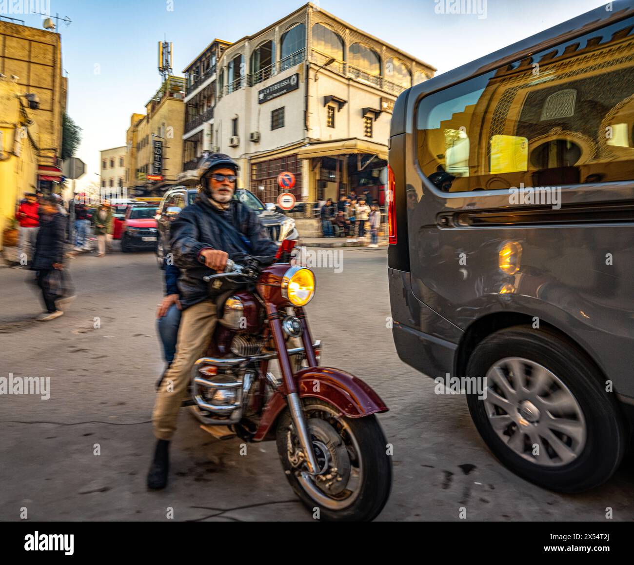 Motorradfahrer, der den Verkehr in der Nähe von Bab Bou Jeloud in Fès navigiert. Stockfoto