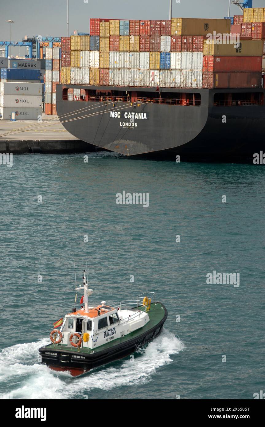 Pilotboot und Containerfrachter in einem Industriehafen Stockfoto