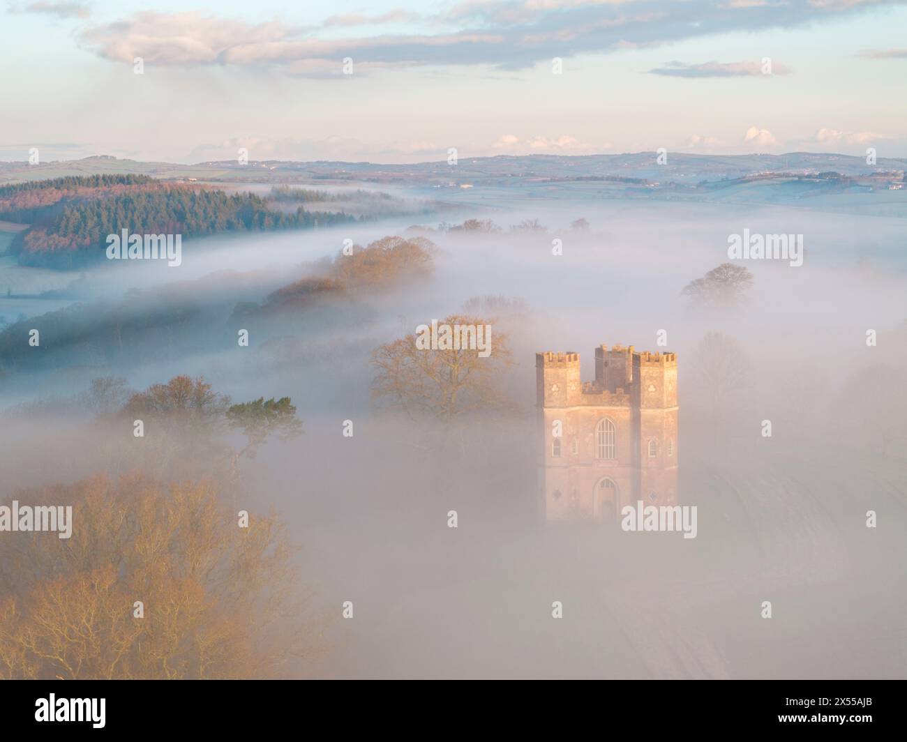 Morgennebel umgibt den Belvedere-Turm bei Sonnenaufgang an einem Wintermorgen, Powderham Castle, Devon, England. Winter (März) 2024. Stockfoto