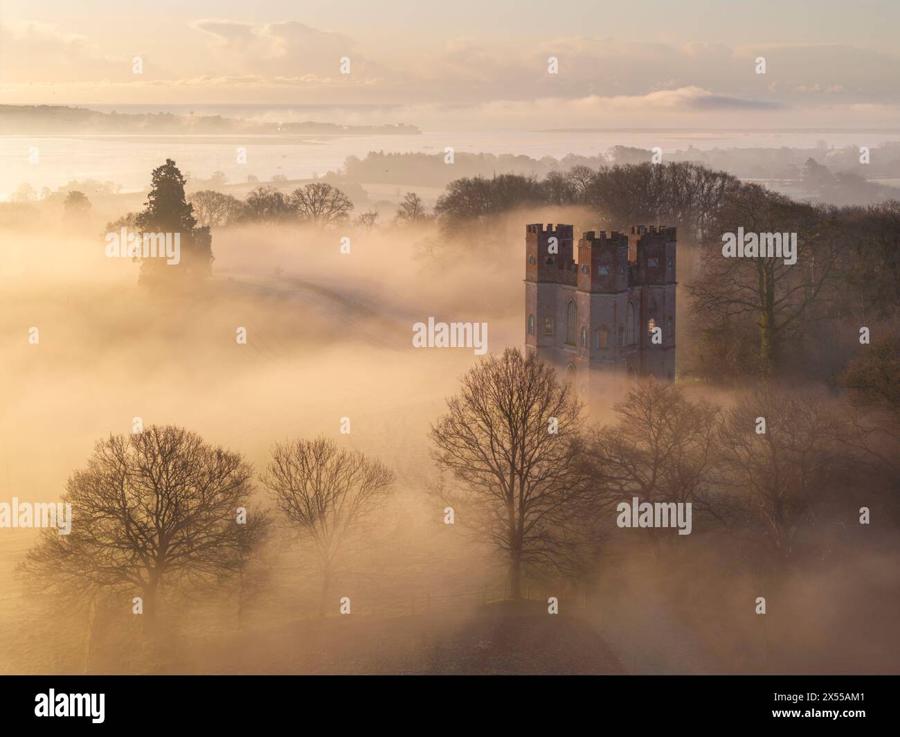 Morgennebel umgibt das Belvedere bei Sonnenaufgang an einem Wintermorgen in Powderham, Devon, England. Winter (März) 2024. Stockfoto