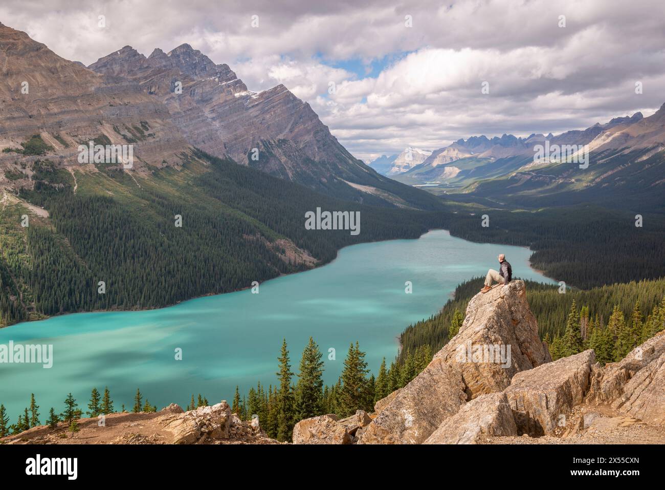 Mann sitzt auf Felsen mit Blick auf den Peyto Lake in den Kanadischen Rockies, Banff National Park, Alberta, Kanada. Stockfoto