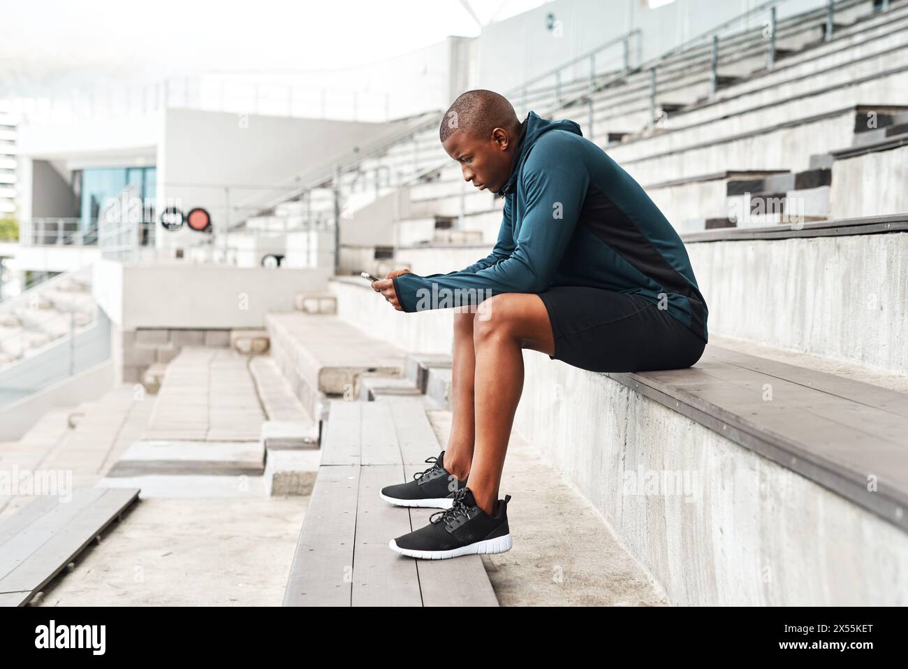 Steps, Läufer und Schwarzer mit Telefon in sozialen Medien, Online-Chat oder Nachrichten über Fitness in der Pause. Entspannen Sie sich, Stadion und Sportler tippen in der Arena mit Stockfoto