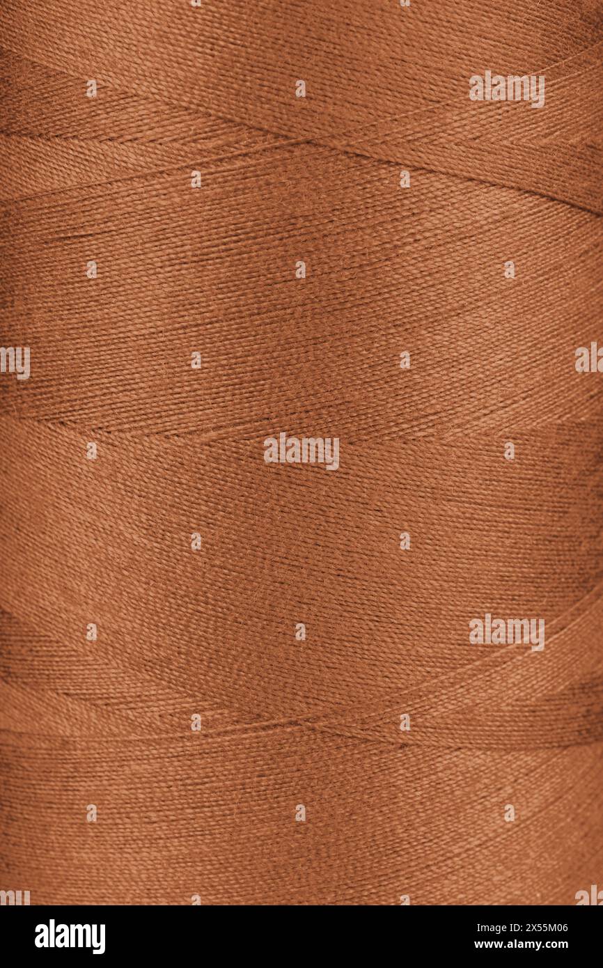 Textur von orangefarbenen Gewinden in der Spule Nahaufnahme, Makro. Nähgarne Spule abstrakt Hintergrund, Tapete, Hintergrund. Stockfoto