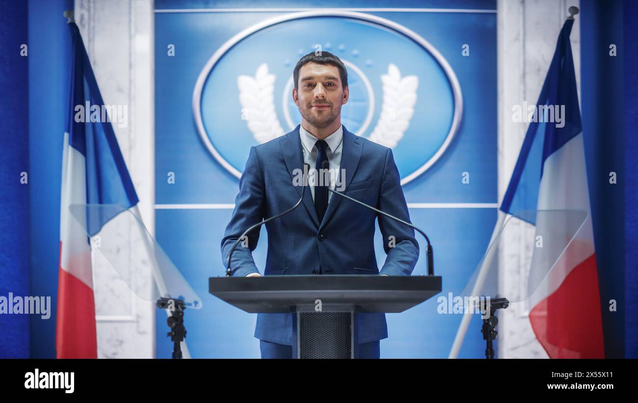 Junge Vertreterin der Organisation bei Pressekonferenz im Regierungsgebäude. Pressesprecher hält eine Rede auf dem Gipfel. Minister im Gespräch mit dem Kongress. Hintergrund mit französischen Flaggen. Stockfoto