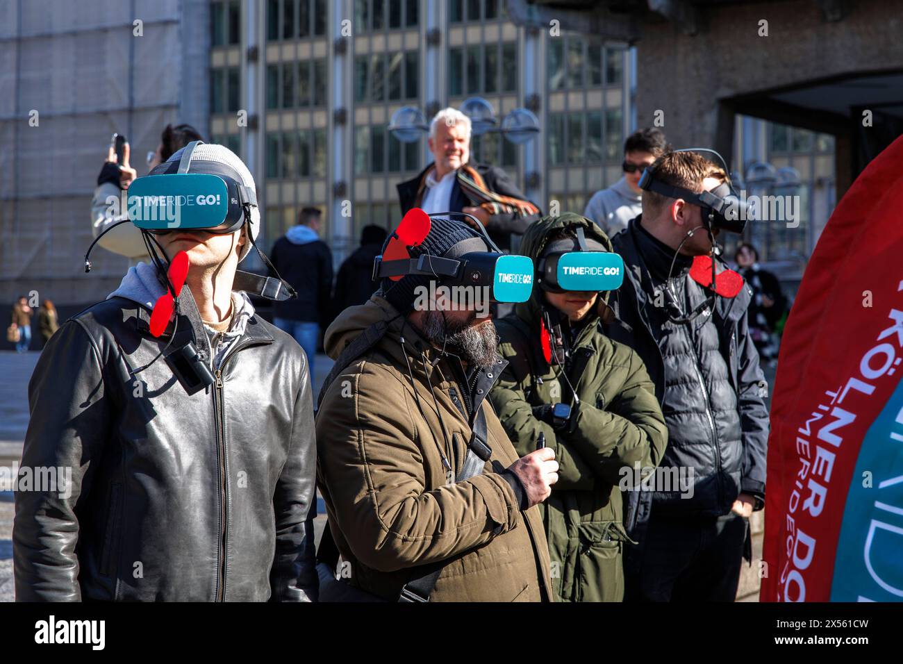 Touristen mit Virtual-Reality-Brille vor dem Kölner Dom Köln, Deutschland. Das Unternehmen TIMERIDE bietet Stadtführungen mit Virtual-Reality-Glas an Stockfoto