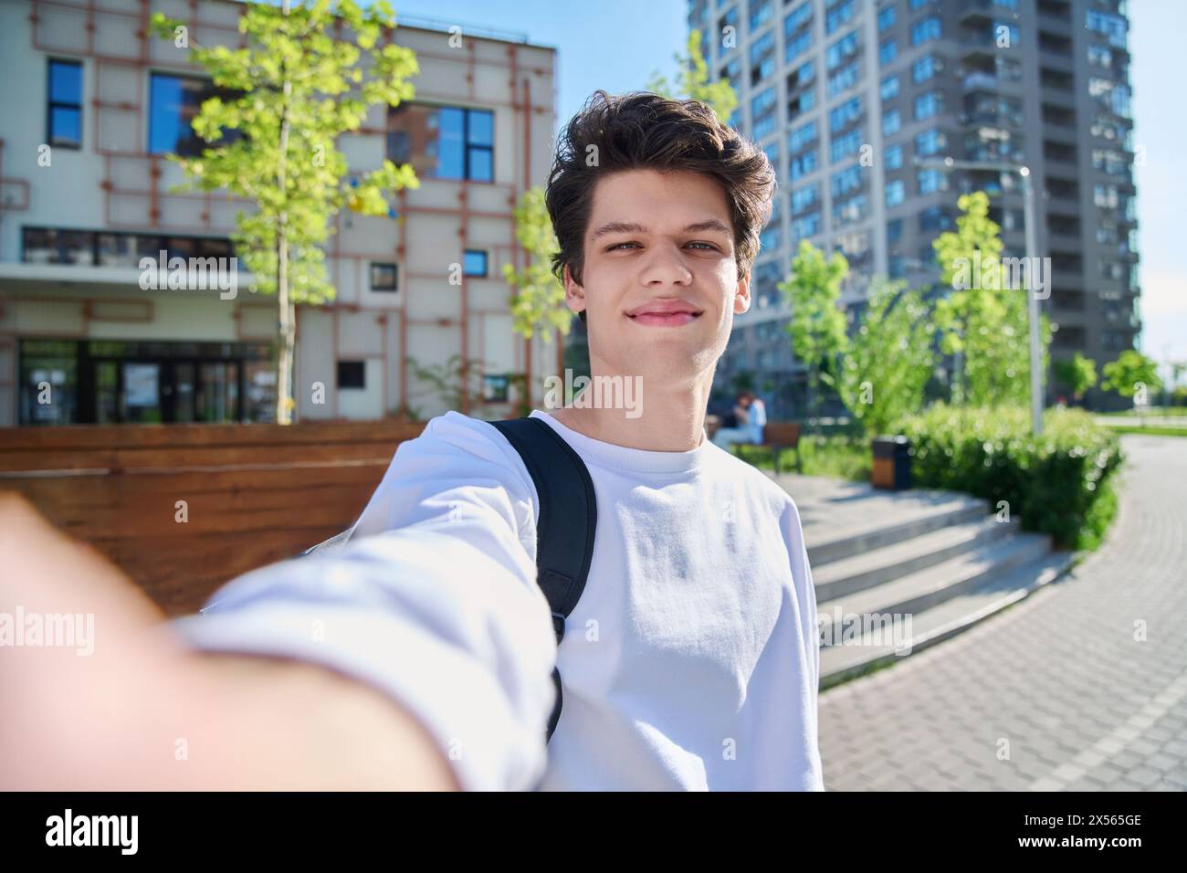 Selfie-Porträt eines jungen glücklichen, gutaussehenden Mannes mit lockigen Haaren, Guy University Student im Freien. Jugend, urbaner Stil, 19,20 Jahre männlich, Lebensstil c Stockfoto