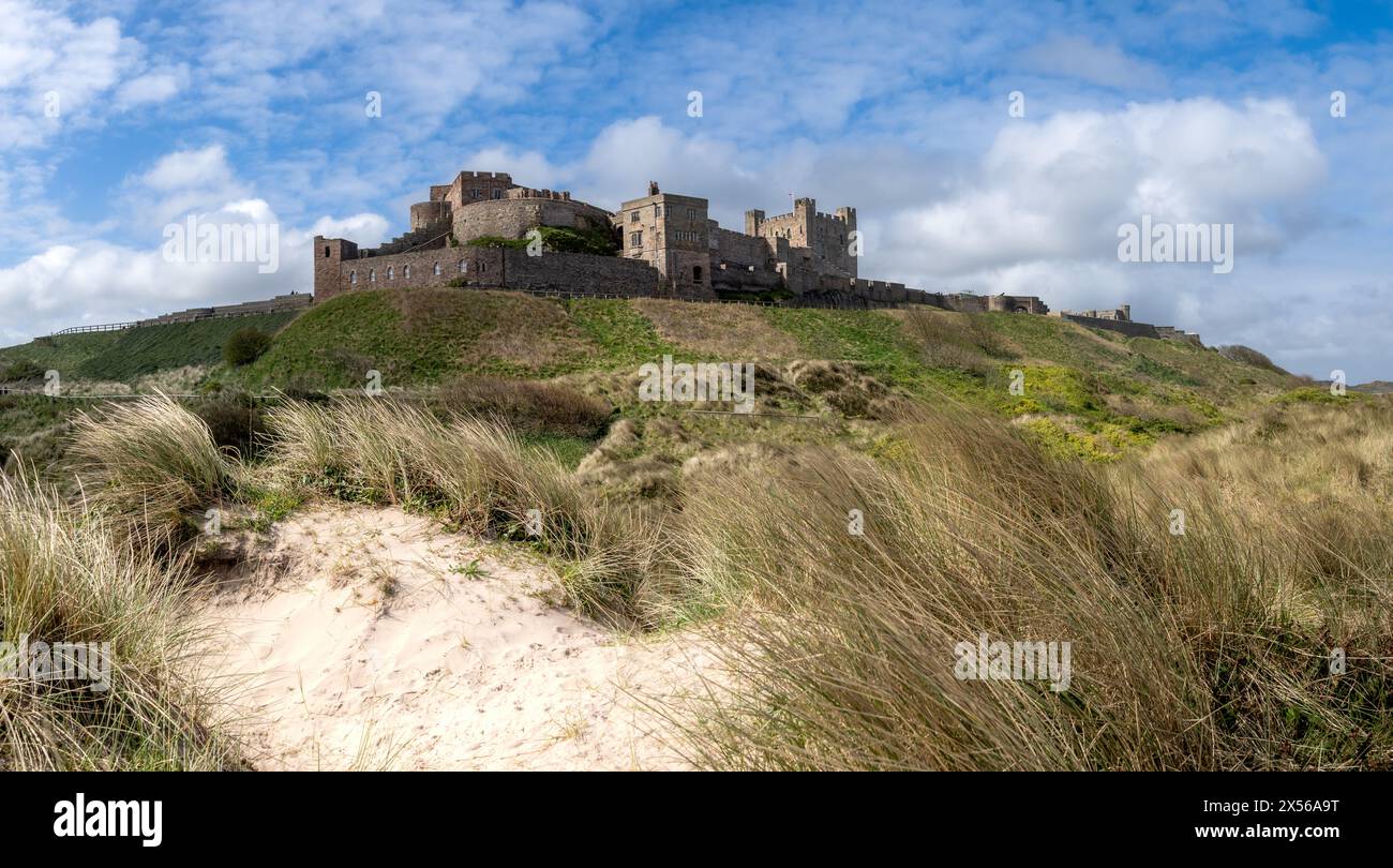 BAMBURGH CASTLE, NORTHUMBERLAND, GROSSBRITANNIEN - 23. APRIL 2024. Panoramablick auf Bamburgh Castle und Sanddünen an der wunderschönen Küste von Northumberland Stockfoto