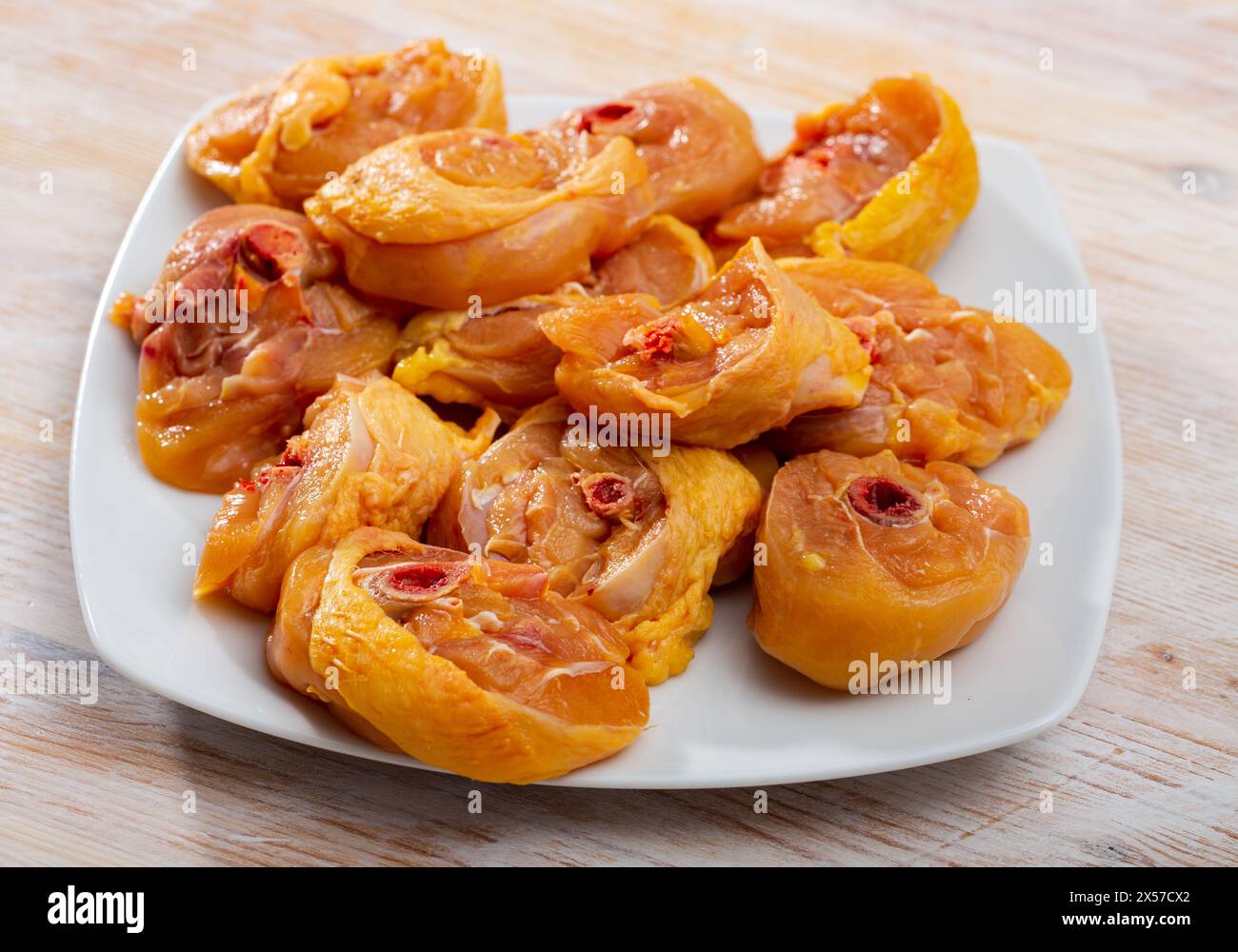 Bild von frischen, rohen Hähnchenschenkeln auf einer Holzfläche Stockfoto