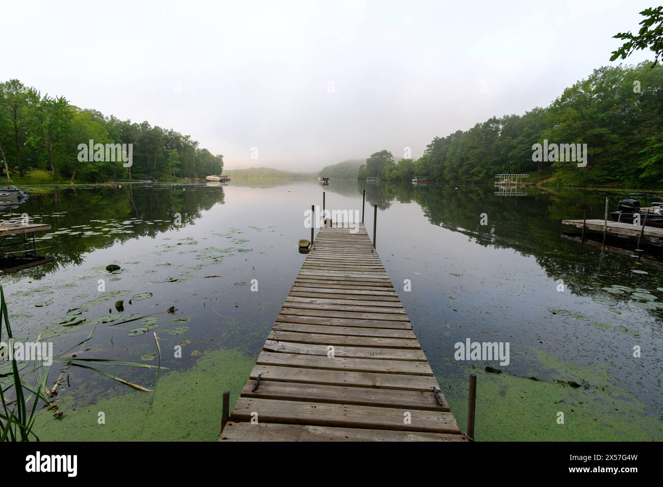 An einem nebeligen Morgen auf einem ruhigen Wisconsin-See. Fischerboot in der Ferne. Stockfoto