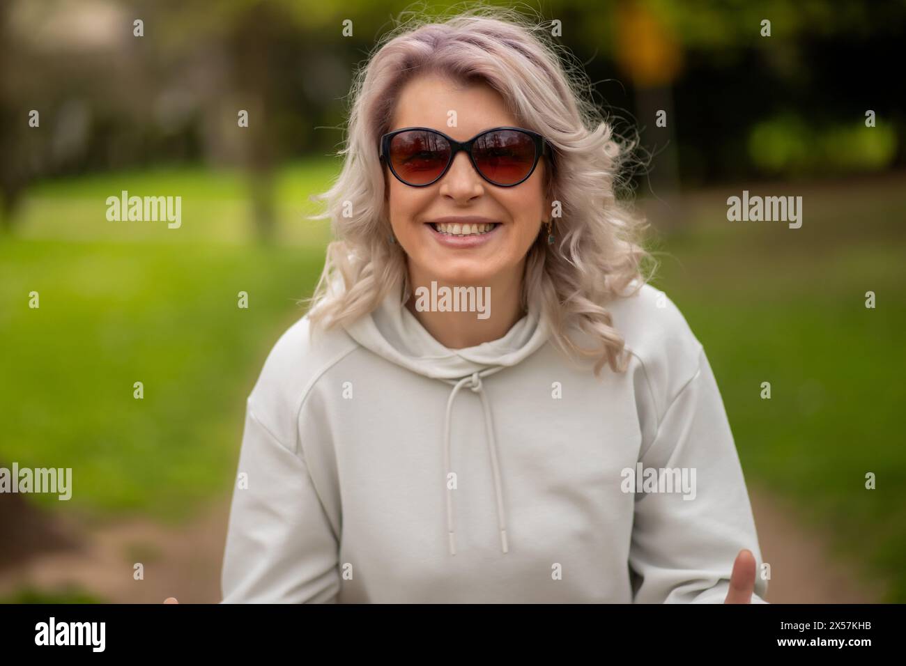 Stilvolle Frau mit silbernem Haar im Park. Stockfoto