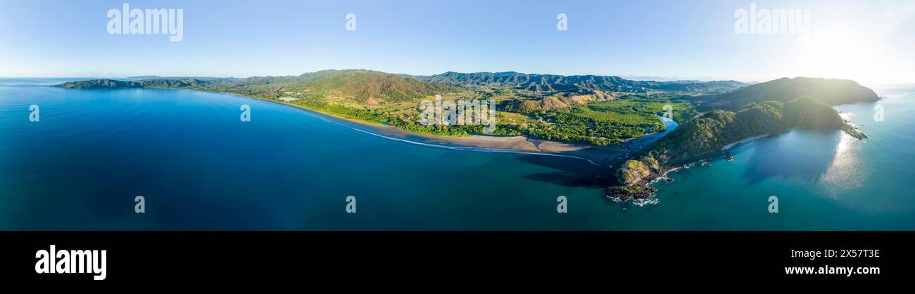 Panoramablick auf eine grüne, bewaldete Küstenlandschaft mit blauem Meer und Himmel, Pochote, Puntarenas, Costa Rica Stockfoto