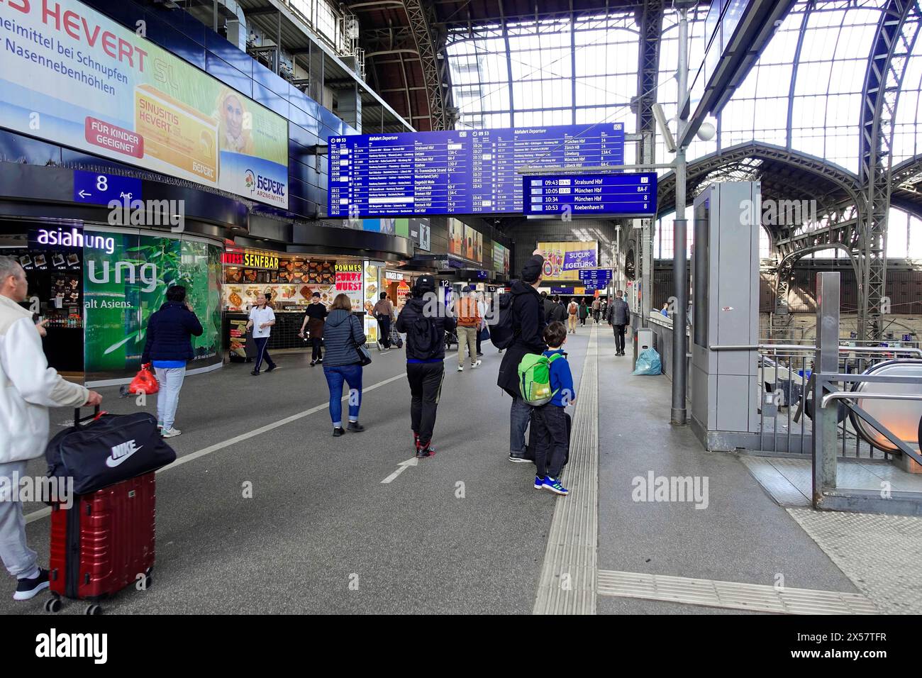 Hamburg Hauptbahnhof, Hamburg, Deutschland, Europa, lebhafte Szene in einer Bahnhofshalle mit Menschen, Geschäften und einer großen Schautafel im Stockfoto