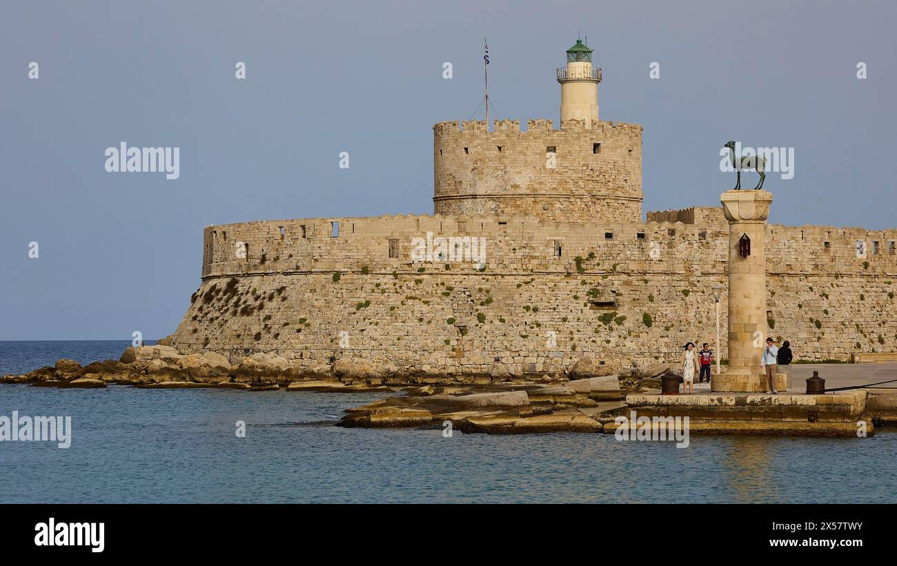 Leute schlendern an einer Säule in der Nähe einer alten Festung am Meer vorbei, Fort von St. Nikolaos, Europäische Rehstatue, Hafenviertel, Rhodos-Stadt, Rhodos Stockfoto