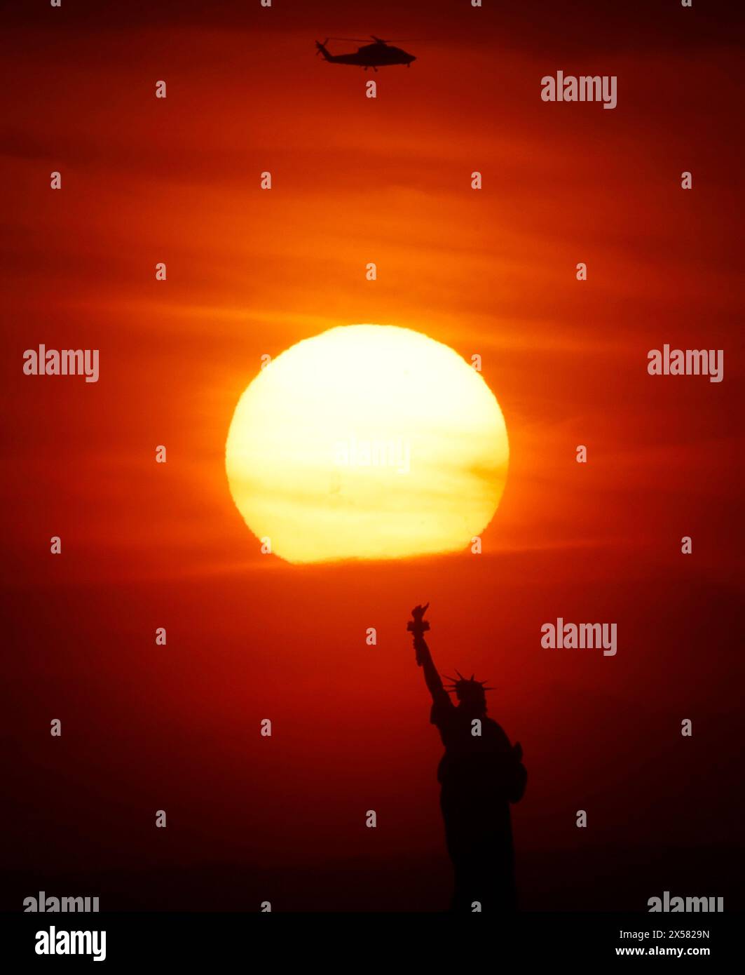 Brooklyn, Usa. Mai 2024. Die Sonne untergeht am Dienstag, 7. Mai 2024, hinter der Freiheitsstatue in New York City. Foto: John Angelillo/UPI Credit: UPI/Alamy Live News Stockfoto