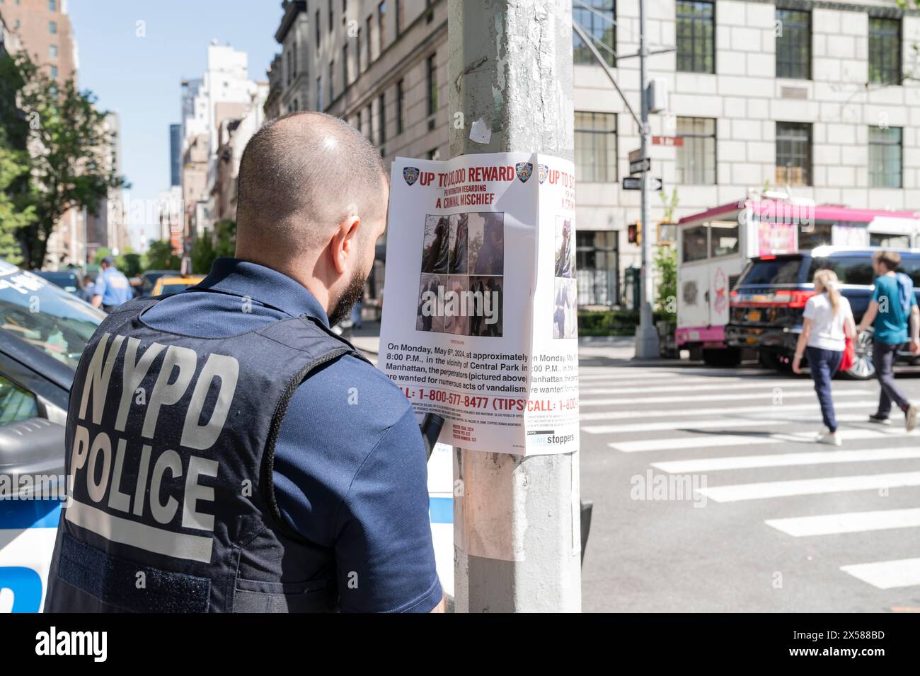 New York, New York, USA. Mai 2024. Am 7. Mai 2024 stellte der Polizist Wanted Plakate auf der 5th Avenue in New York auf, wegen des jüngsten Vandalismus des 107th Infantry Memorial im Central Park. Bis zu 10.000 US-Dollar werden von NYPD Crime Stoppers vergeben, wobei ein zusätzlicher Betrag von bis zu 5.000 US-Dollar mit dem persönlichen Geld von Bürgermeister Adams zum Gedenken an seinen Onkel Joe, der mit 19 Jahren in Vietnam starb, aufgebracht wird. (Kreditbild: © Lev Radin/ZUMA Press Wire) NUR REDAKTIONELLE VERWENDUNG! Nicht für kommerzielle ZWECKE! Stockfoto