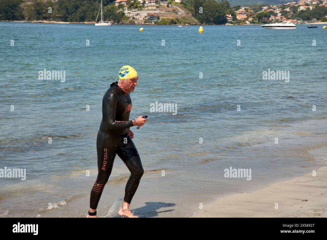 Sabaris, Baiona, Pontevedra, Spanien; 15. Juli, 2023: Triathlon-Teilnehmer tauchen in ihren Neoprenanzügen aus dem Wasser auf Stockfoto