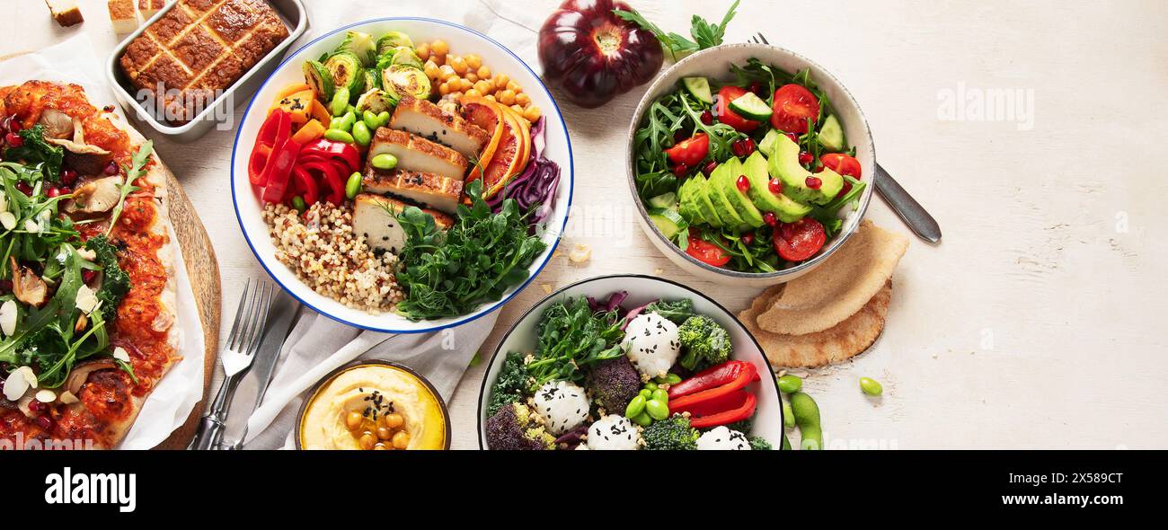 Vegetarisches Lebensmittelkonzept. Gesundes vegetarisches Essen, Salat, Avocado, Pizza und buddha Schüssel auf hellem Hintergrund, Blick von oben. Panorama mit Kopie sp Stockfoto